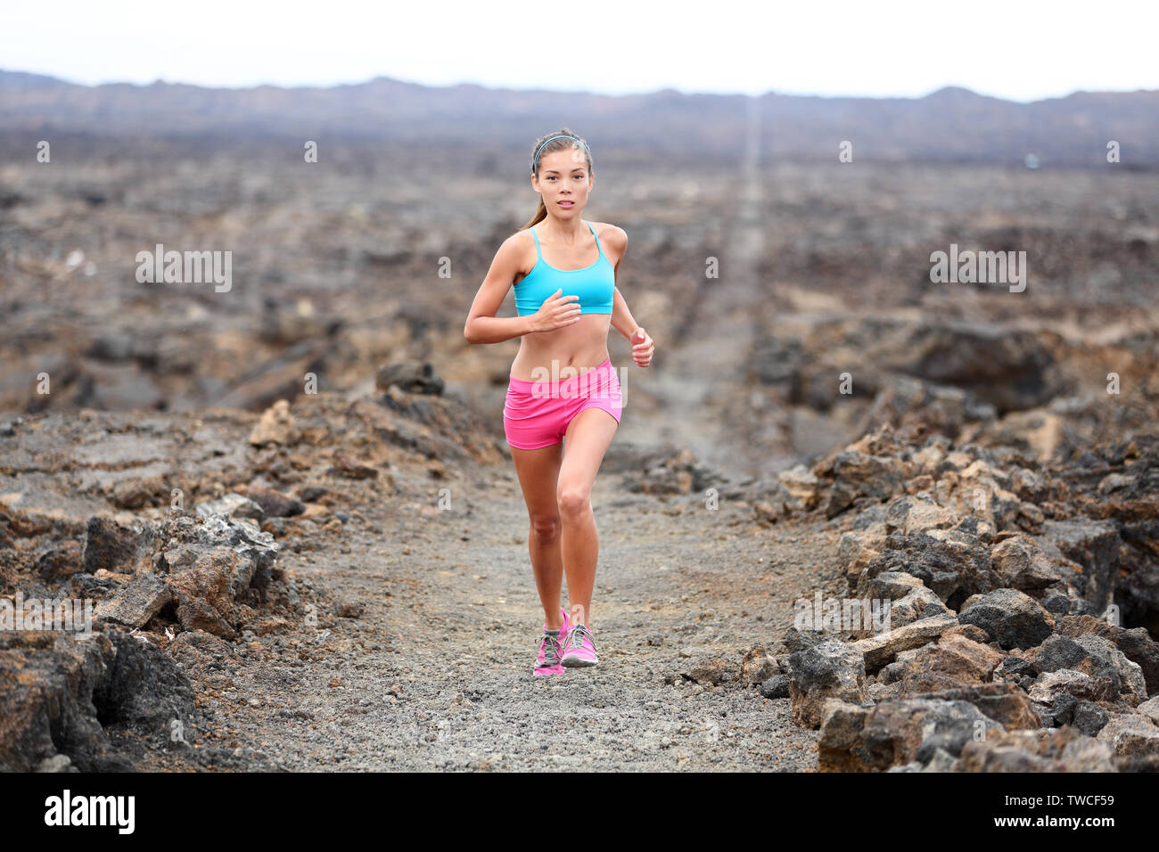 Runner mujer triatleta trail running cross country funcionando fuera del volcán. Atleta Femenina entrenamiento de jogging para carrera de maratón fuera en un bello paisaje en Big Island, Hawaii, USA. Foto de stock