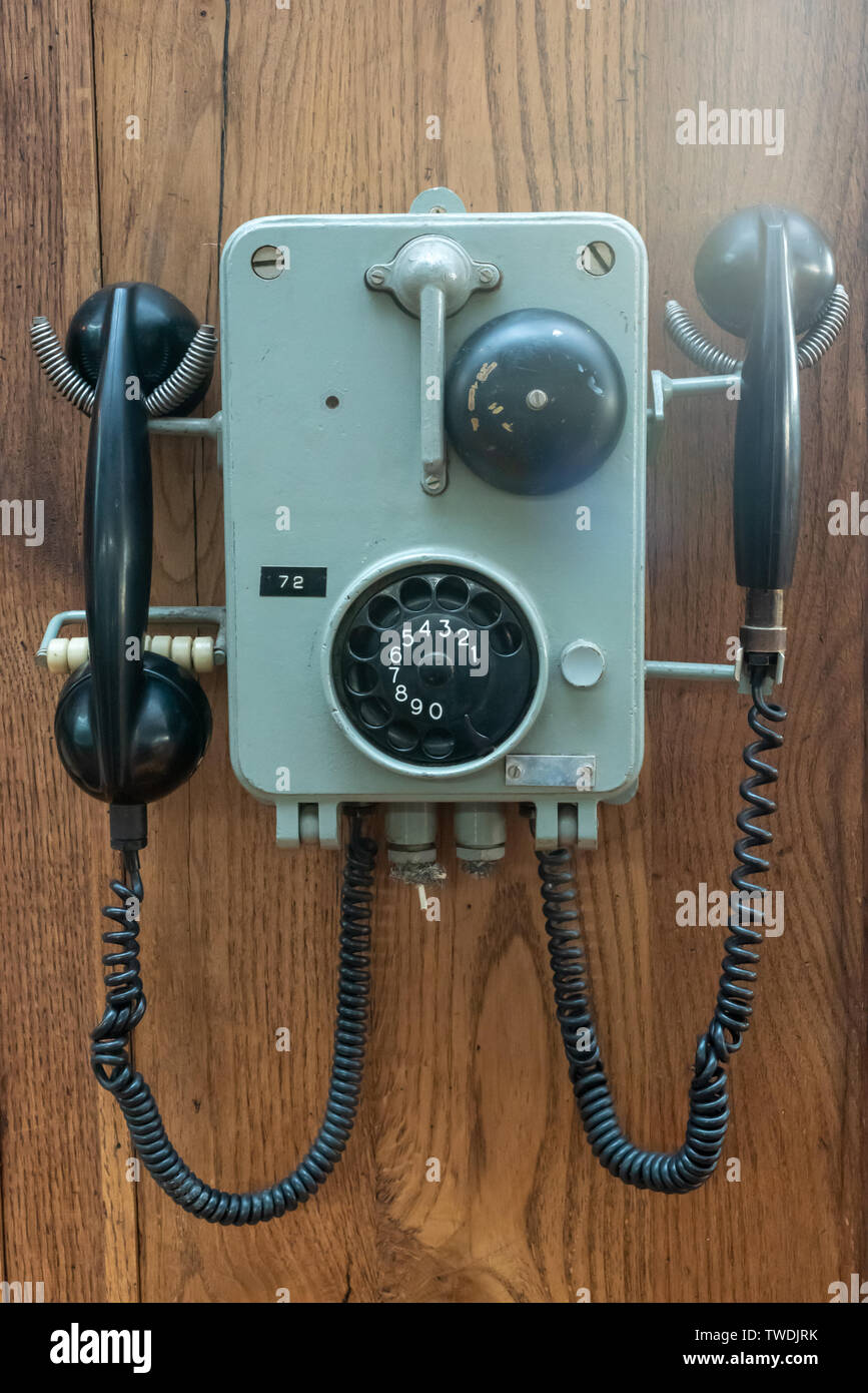 Antiguo teléfono colgado en una pared de madera vista cercana Foto de stock
