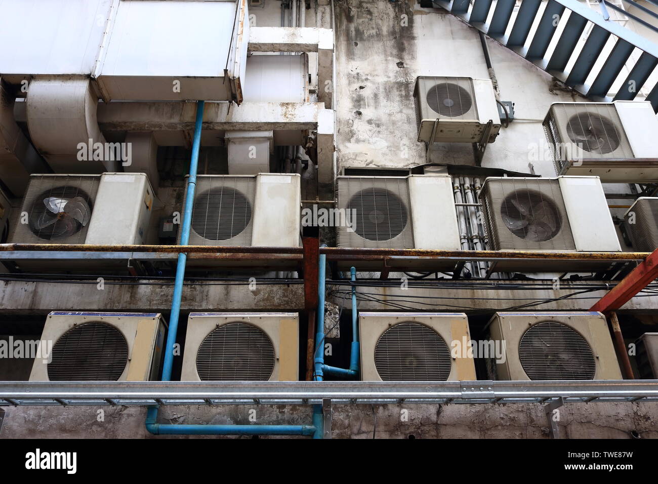 Grupo de unidades condensadoras de acondicionadores de aire instalado en el dosel detrás del edificio, detrás de las escenas, concepto Foto de stock