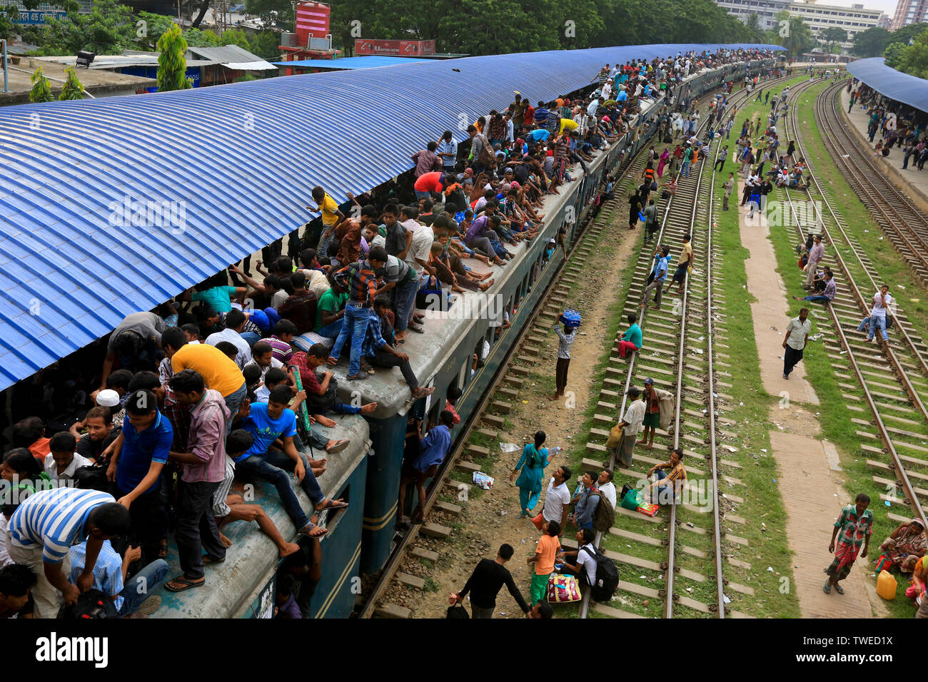Home-bound personas luchan para obtener el techo de un tren en la estación de trenes del aeropuerto por delante del Eid-ul-Fitr. Dhaka, Bangladesh. Foto de stock