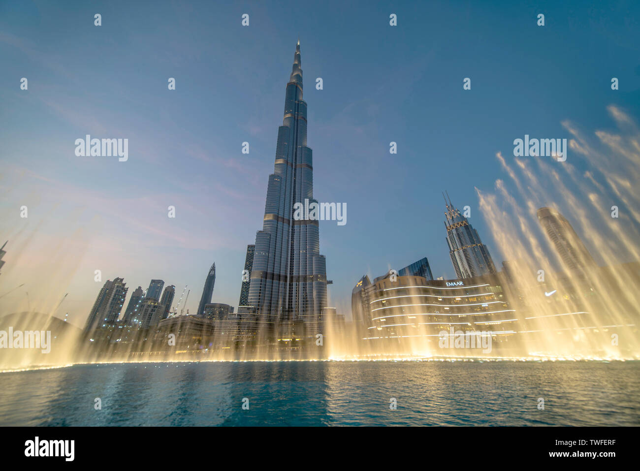 El Dubai Fountain bailes en luz dorada bajo el Burj Khalifa. Foto de stock