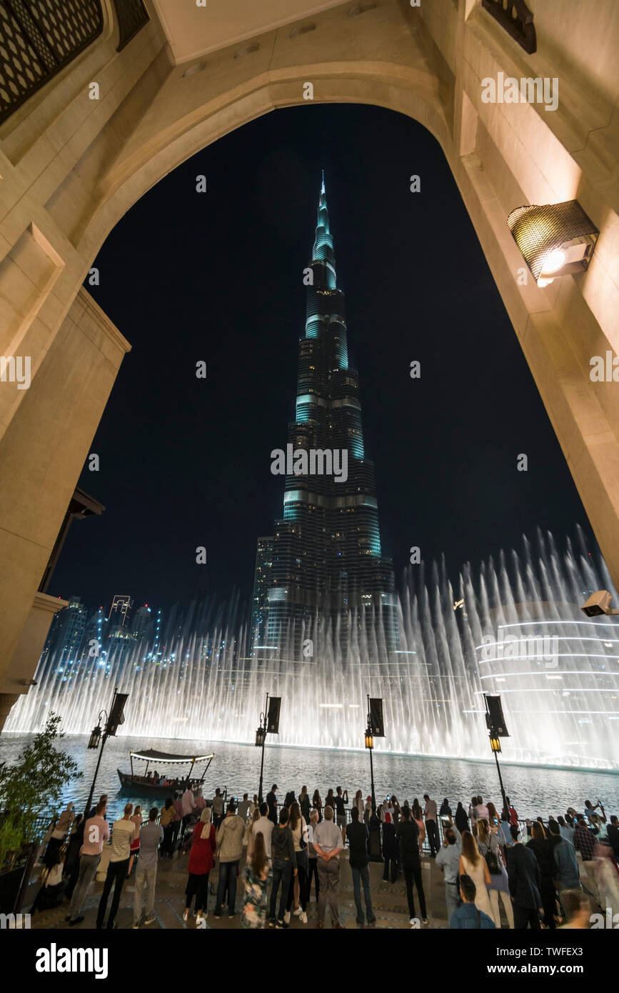 El Burj Khalifa está enmarcado por un elegante arco como multitudes ver las fuentes que bailan. Foto de stock