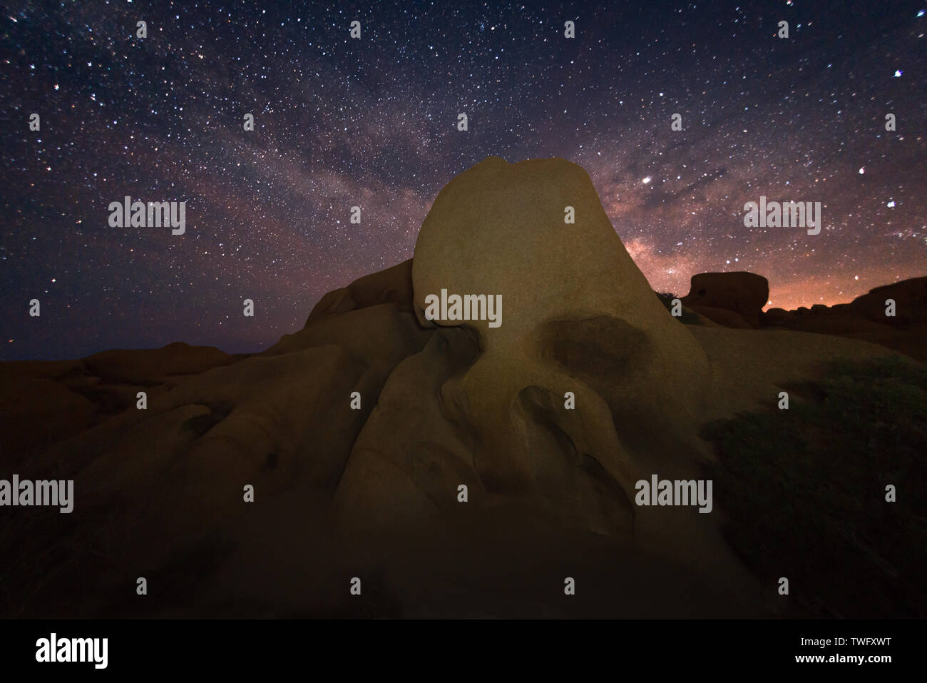 Cráneo de roca y la Vía Láctea, el Parque Nacional Joshua Tree National Park, California, Estados Unidos Foto de stock