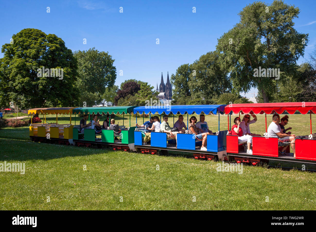 Trenes en miniatura en el parque del Rin en el distrito Deutz, vistas a la catedral de Colonia, Alemania. Im en el Rheinpark Kleinbahn Deutz, Blick zum Dom, K Foto de stock