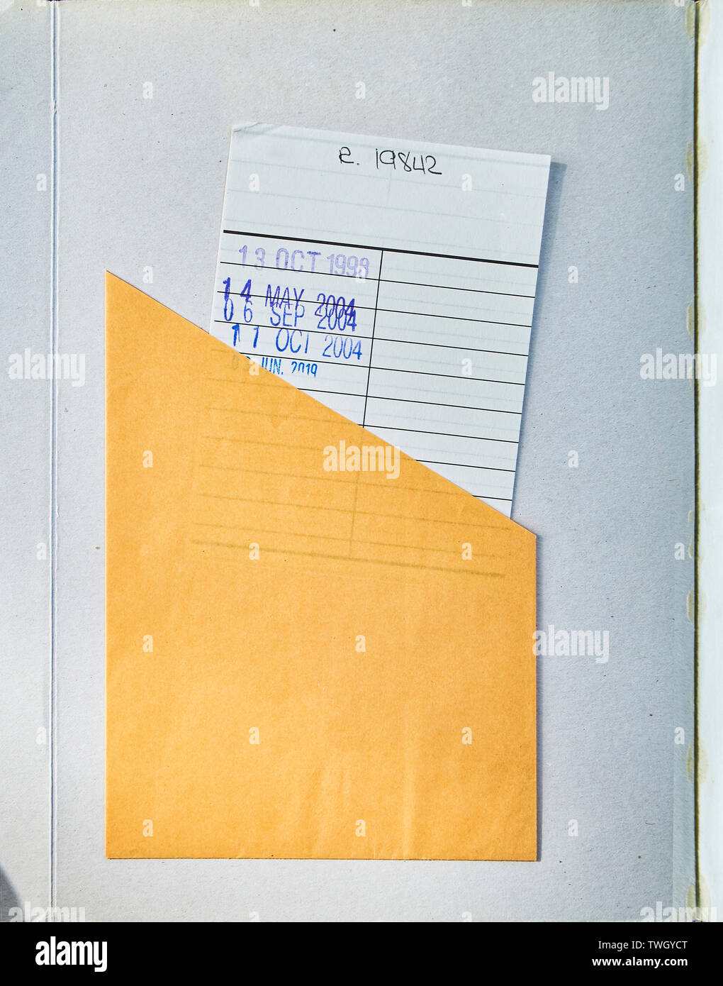 Biblioteca pública libro abierto a la primera página mostrando texturado envejecido cubierta con un cheque o tarjeta fecha de vencimiento. Foto de stock