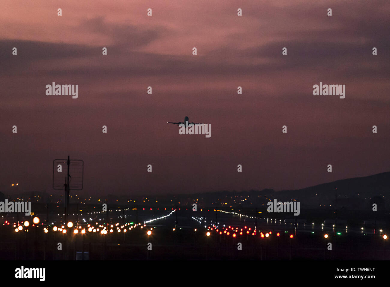 Los aviones de pasajeros partiendo desde el Aeropuerto Internacional de Ciudad del Cabo al anochecer con la pista de aterrizaje claramente iluminado. Foto de stock