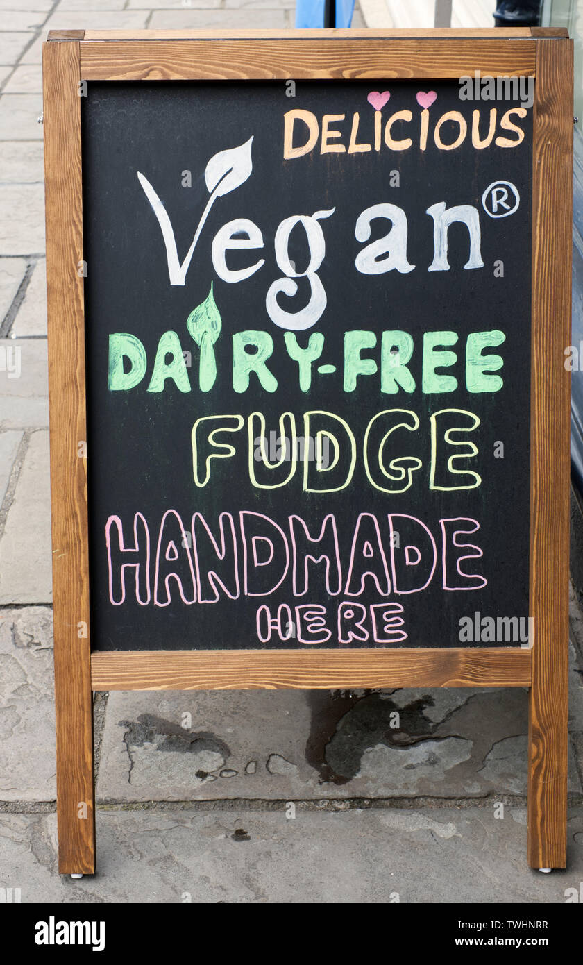 Bastidor A blackboard publicidad Fudge vegano fuera de una tienda de dulces en Wells, Somerset Foto de stock