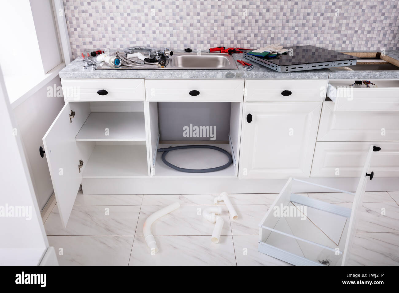 Instalación de una cocina eléctrica vitrocerámica de inducción y el  fregadero de la cocina con muebles herramientas Fotografía de stock - Alamy