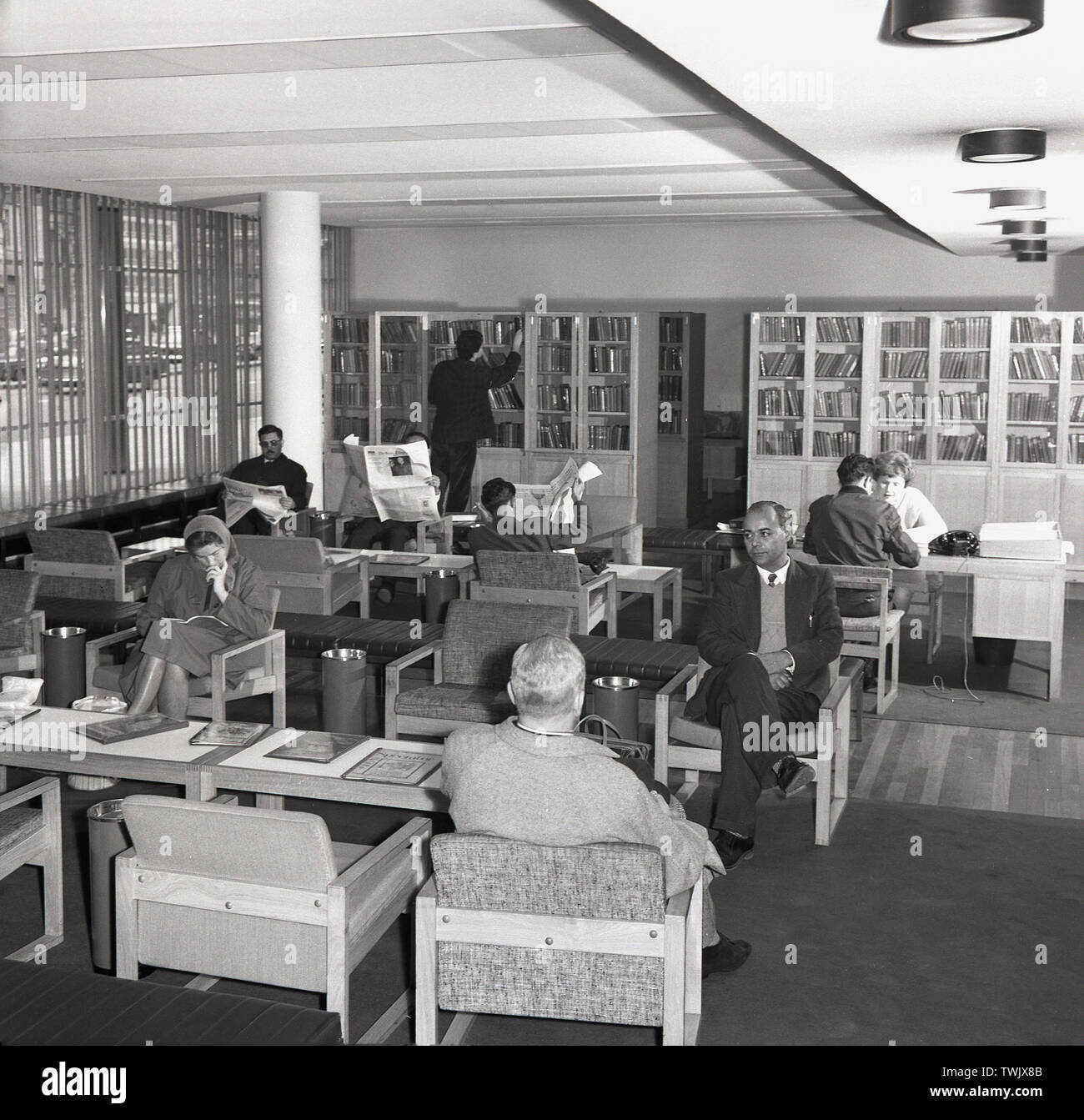 1960, historcial, zona de recepción del British Council en Atenas, Grecia, mostrando la gente sentada en el área de espera. Foto de stock