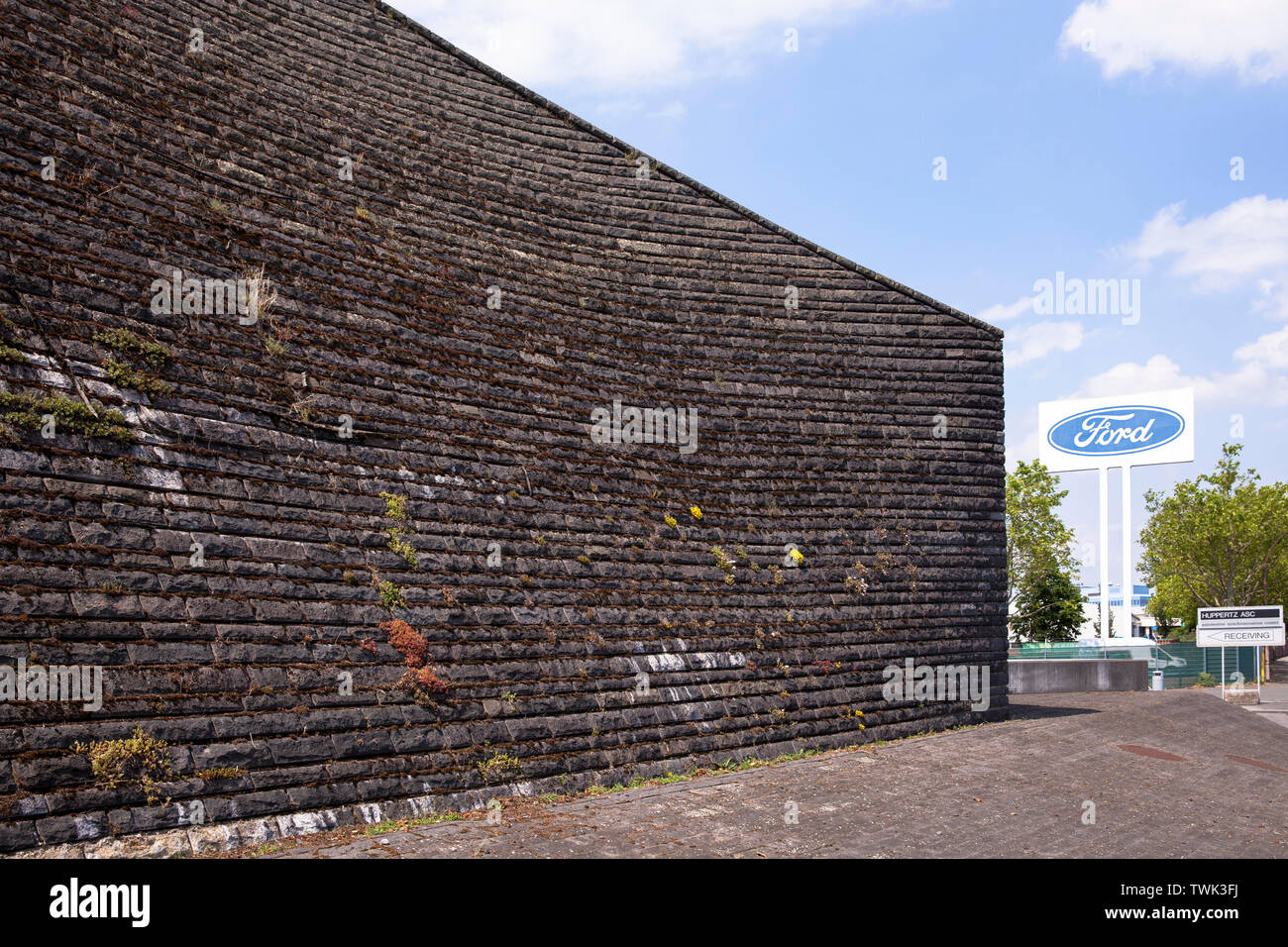 Fachada de basalto del diluvio, la estación de bombeo en el río Rin en Koeln-Niehl, la vegetación de la pared de musgo y otras plantas es intencional, como Foto de stock