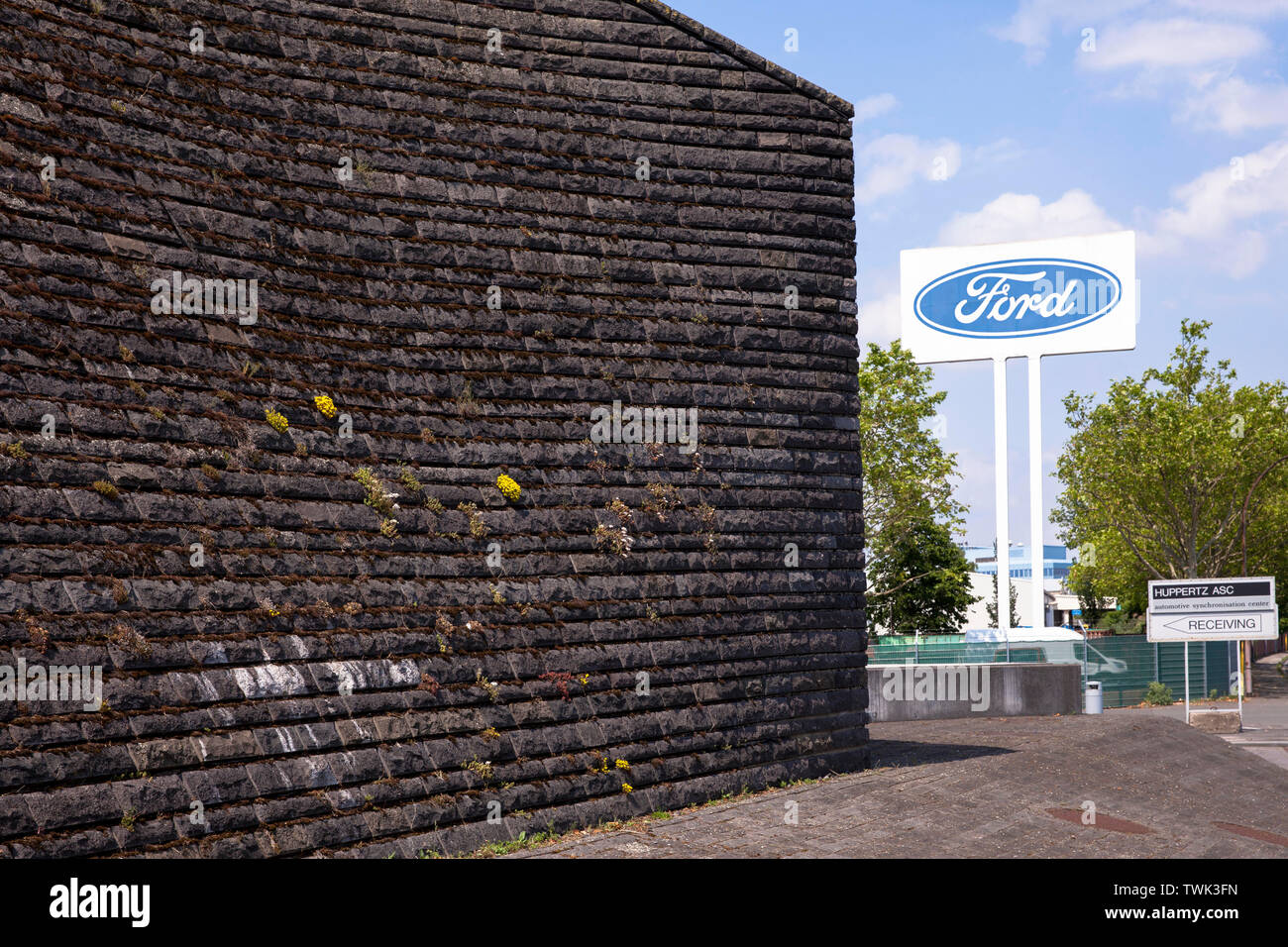 Fachada de basalto del diluvio, la estación de bombeo en el río Rin en Koeln-Niehl, la vegetación de la pared de musgo y otras plantas es intencional, como Foto de stock