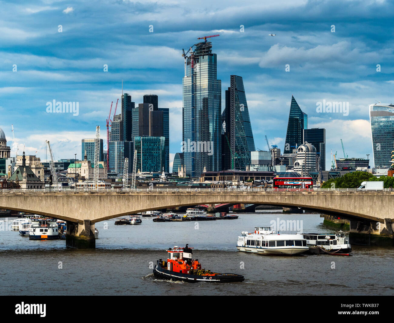 Río Támesis remolcador en el Támesis con la ciudad de Londres y Waterloo Bridge detrás Foto de stock