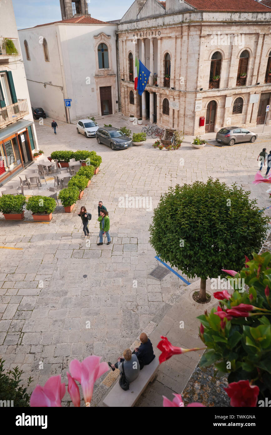 Conversano,Italia: Gente irreconocible en la plaza del Conversano, entre las flores y plantas de la primavera de Apulia. Foto de stock