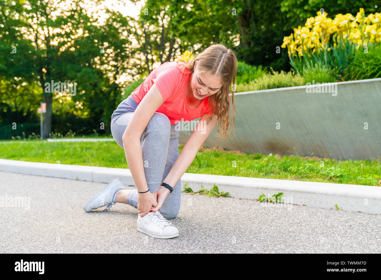 Una mujer tuvo un accidente con su tobillo durante las actividades deportivas y la mantiene apretada Foto de stock