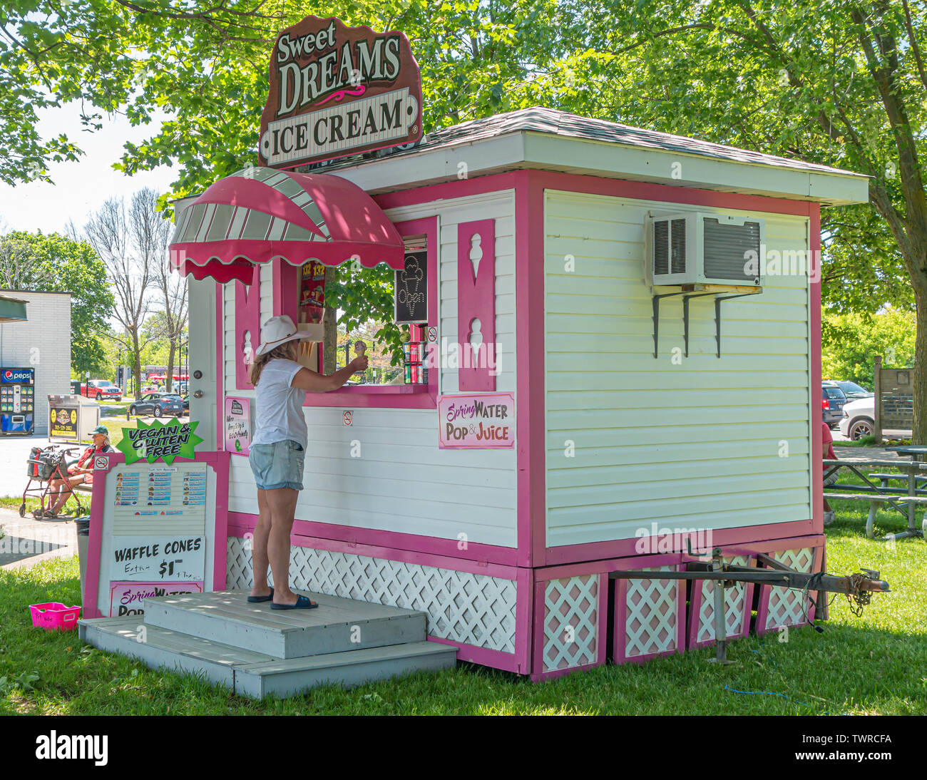 Mujer ordena un cono de helado en un día caluroso de verano en Couchiching Beach Park en Orillia Ontario. Foto de stock