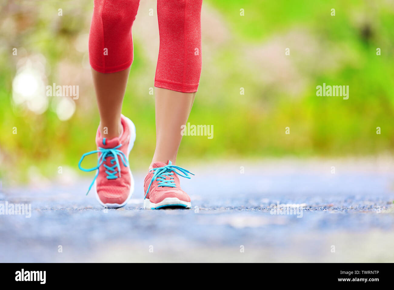 Trotar mujer con piernas atléticas y zapatos para correr. Mujeres caminando por senderos de bosque en concepto de estilo de vida saludable con hasta cerrar en zapatos para correr. La atleta femenina formación emparejador afuera. Foto de stock