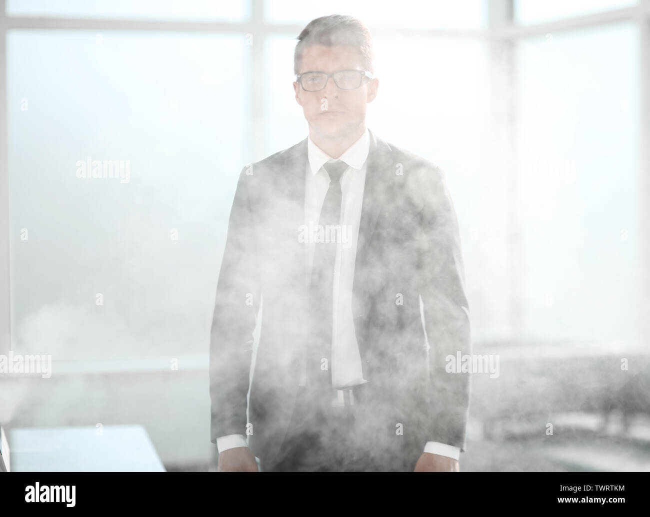 Joven empresario en una oficina ahumado Foto de stock
