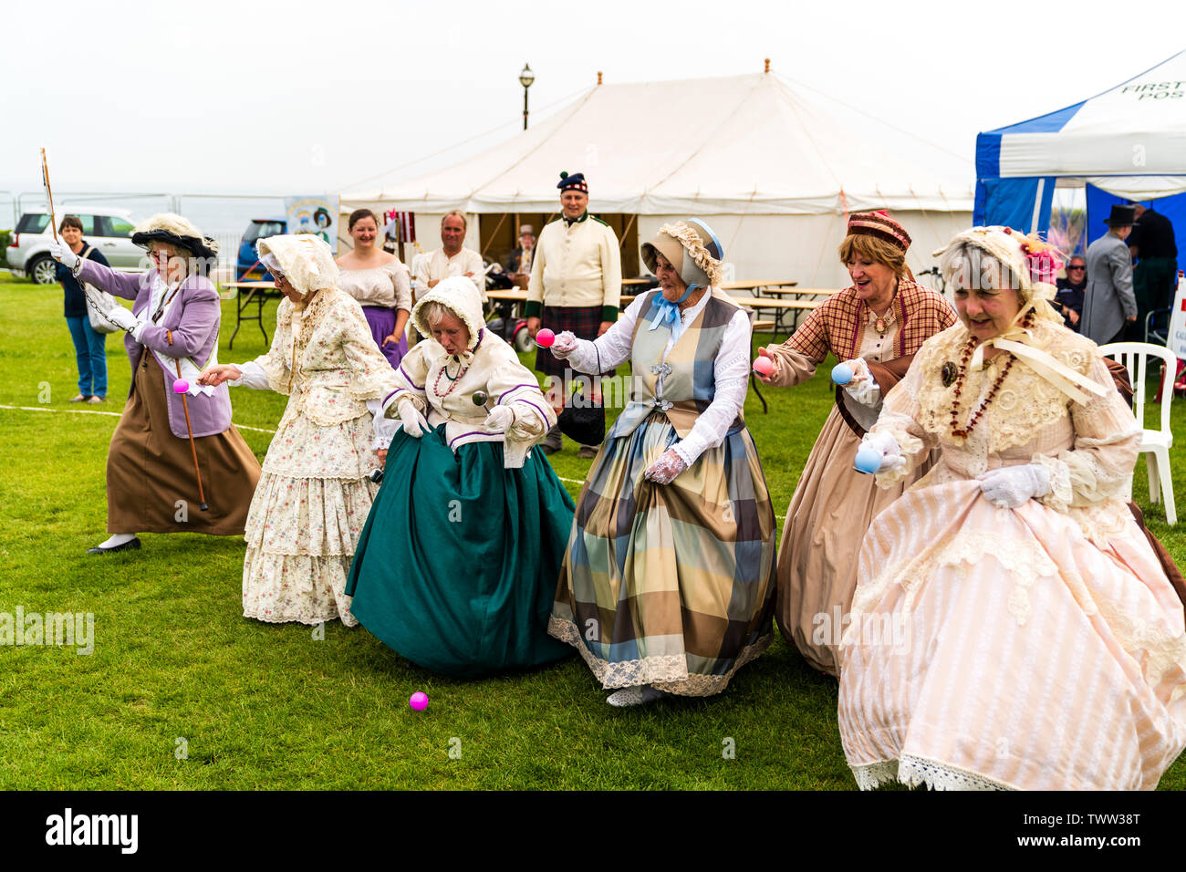 Broadstairs anual Festival Dickens con personas vestidas en trajes Dickensian Victoriana. Grupo de mujeres mayores en trajes y gorros, ejecutando un huevo y cuchara carrera al aire libre. Vista cercana. Foto de stock