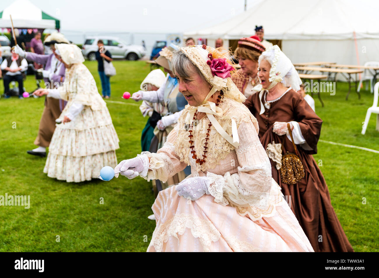 Broadstairs anual Festival Dickens con personas vestidas en trajes Dickensian Victoriana. Grupo de mujeres mayores en trajes y gorros, ejecutando un huevo y cuchara carrera al aire libre. Vista cercana. Foto de stock