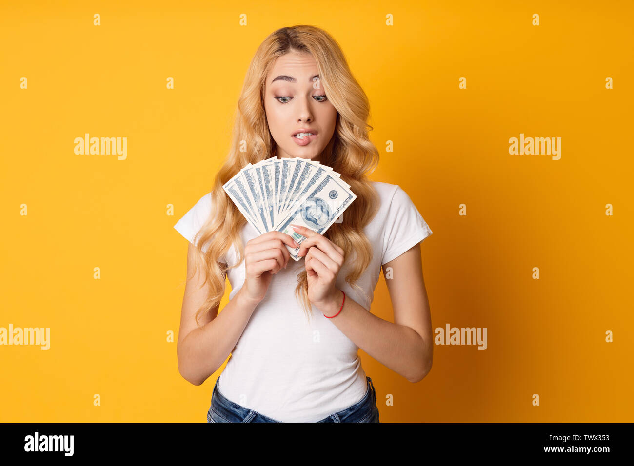 Dudosa Chica sujetando montón de dinero billetes Foto de stock