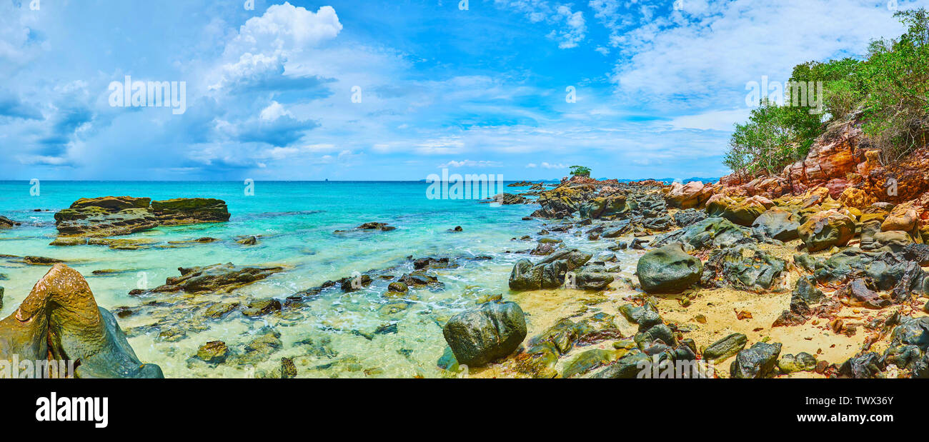 Brillantes aguas color esmeralda del mar de Andamán con miras a cientos de coloridas rocas, cubriendo la orilla de Khai Nai isla, Phuket, Tailandia Foto de stock