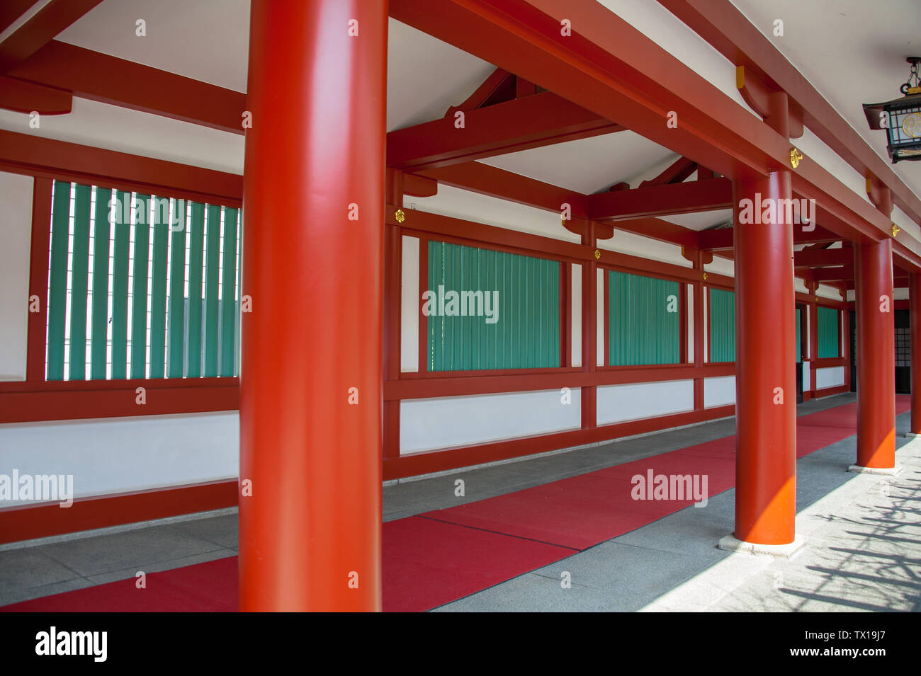 Arquitectura de estilo tradicional japonés en un santuario sintoísta. Pilares de colores Vermillion línea sombreada de un corredor en la antigua Hie Jinja, Tokio Foto de stock