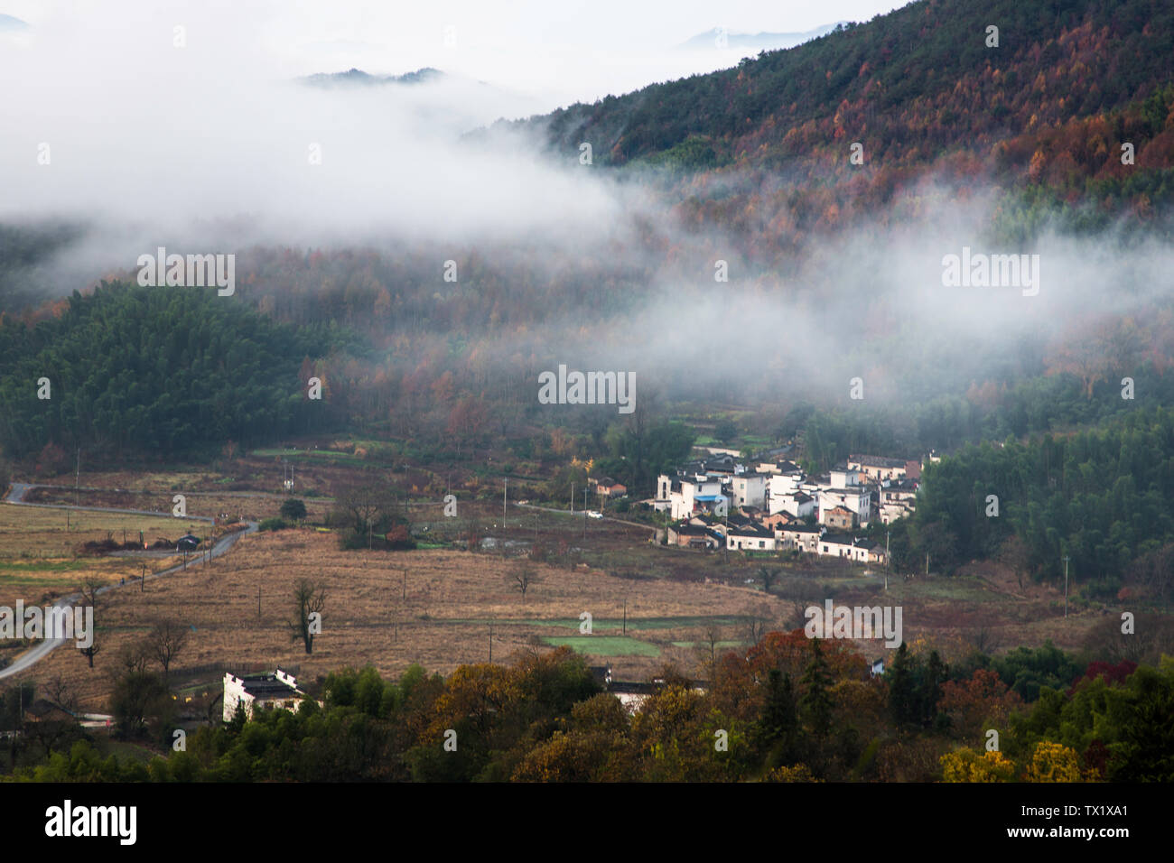 Una antigua aldea envuelto por las nubes y la niebla. Foto de stock