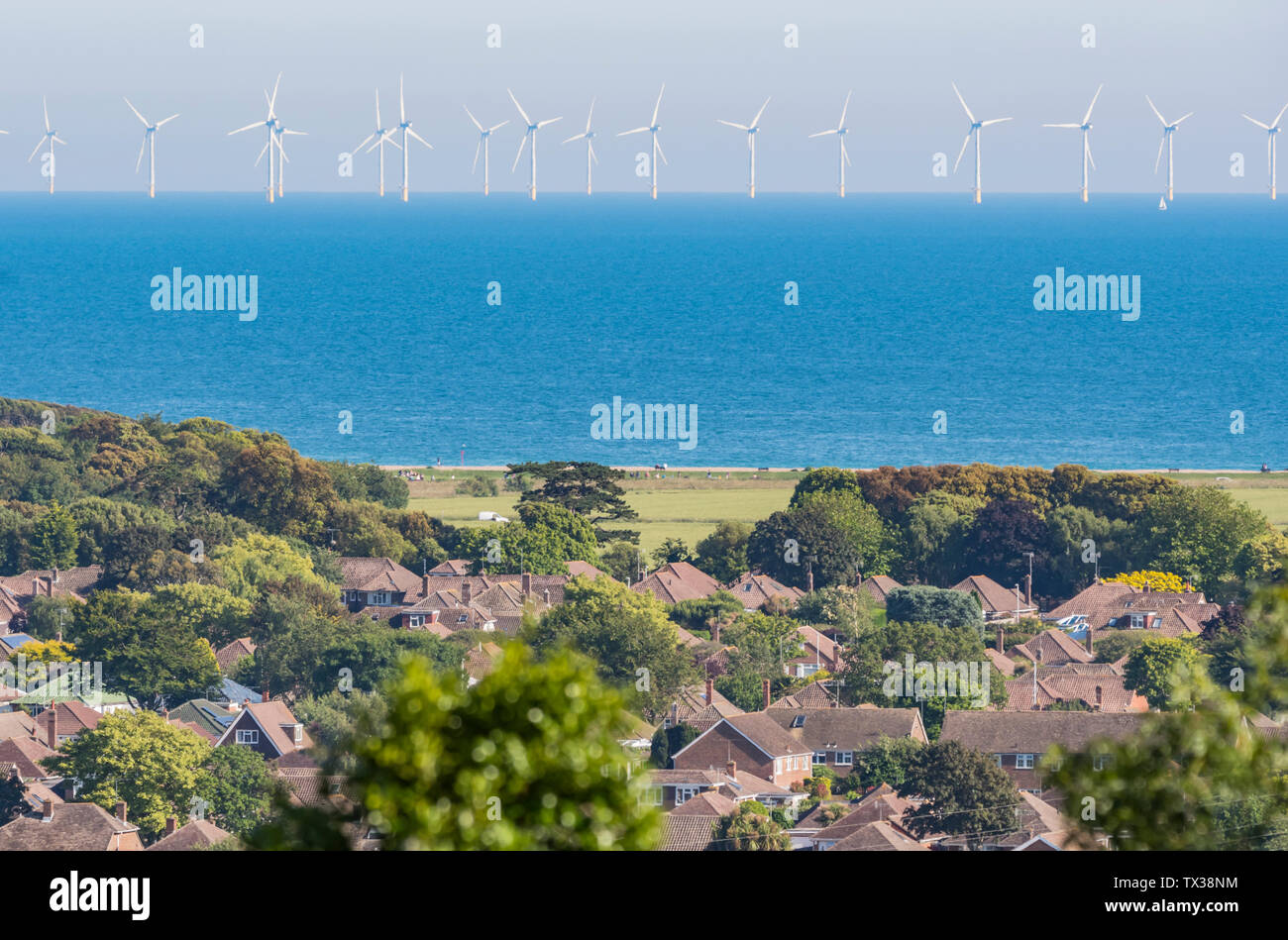 Offshore Rampion turbinas eólicas en el mar frente a la costa sur de Inglaterra, Reino Unido, mostrando la tierra y la vivienda. Energía verde renovable. El calentamiento global. Foto de stock