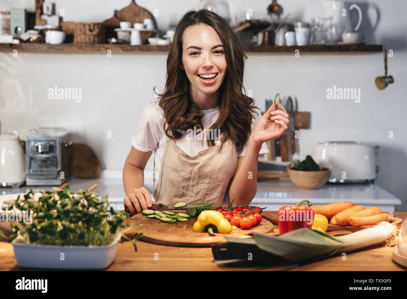 https://c8.alamy.com/compes/tx3gp3/joven-y-bella-mujer-vistiendo-el-delantal-de-cocina-ensalada-saludable-en-la-cocina-de-casa-picar-verduras-tx3gp3.jpg