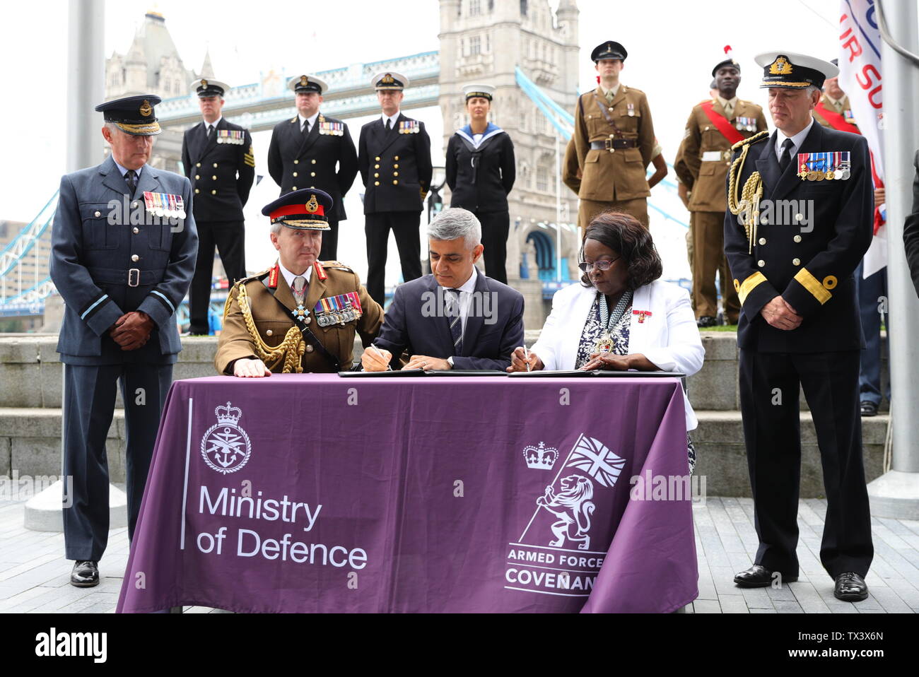 Alcalde de Londres Sadiq Khan (centro), firma el Pacto de las Fuerzas Armadas durante una ceremonia de izamiento de la bandera en el City Hall, Londres, para mostrar su apoyo a los hombres y mujeres que componen la comunidad de las fuerzas armadas antes de día de las Fuerzas Armadas. Foto de stock