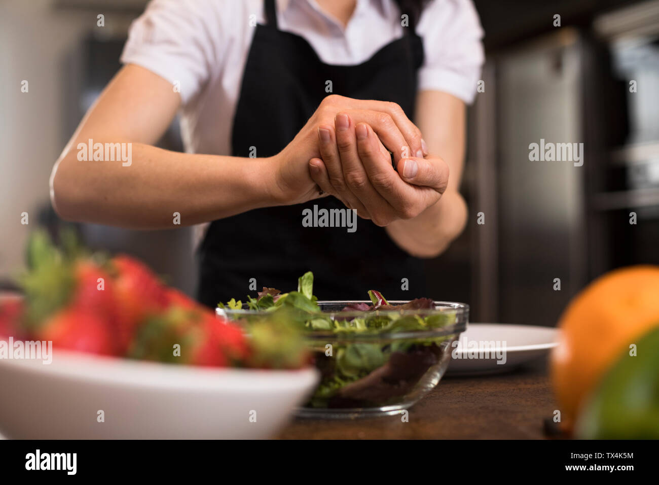 Close-up de Mujer cociendo en la cocina preparando una ensalada Foto de stock