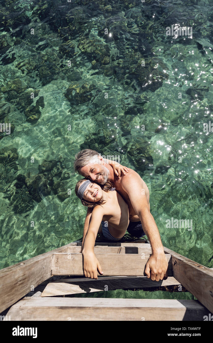 Indonesia, el Parque Nacional de Komodo, feliz, padre e hija, abrazando en el mar Foto de stock
