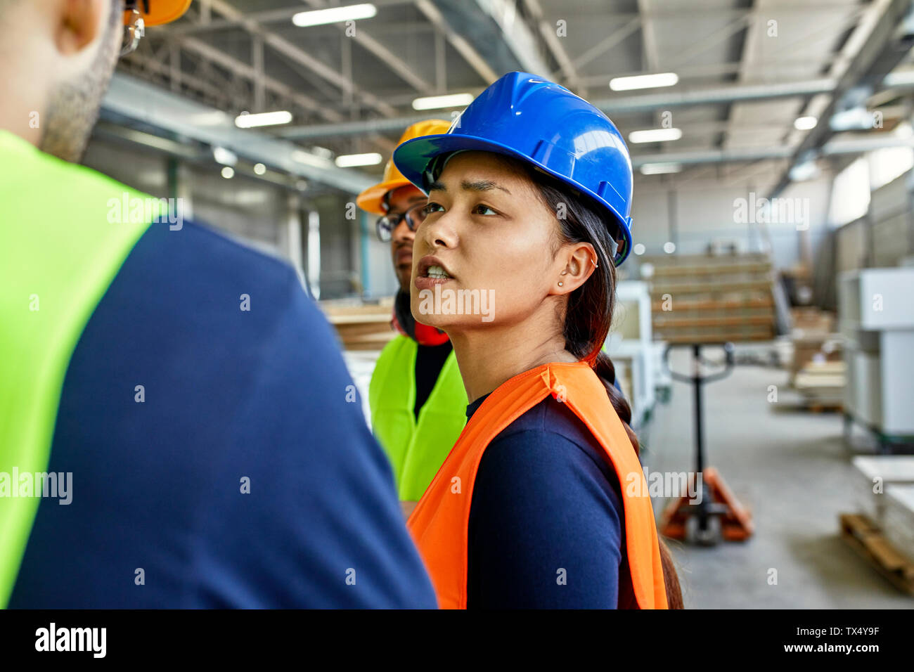 Dos hombres y una mujer en chalecos reflectantes discutiendo la de - Alamy