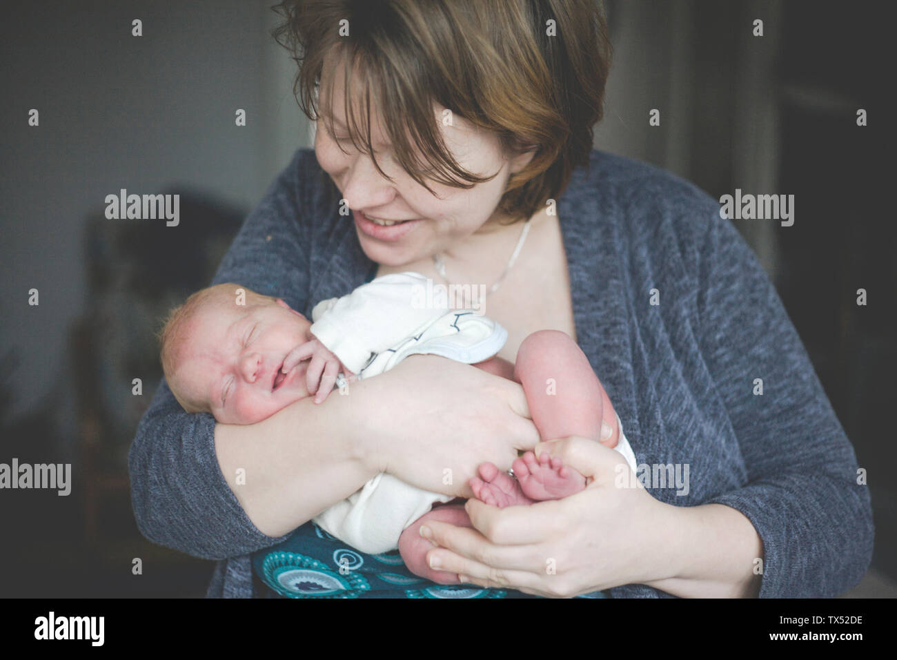 Madre sosteniendo a su bebé recién nacido hija Foto de stock