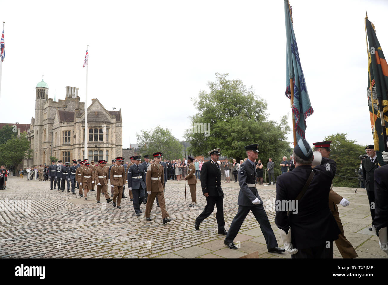 Los miembros de las fuerzas armadas asistir a una ceremonia de izada de bandera al en Winchester para marcar el comienzo de la semana de las fuerzas armadas antes de día de las Fuerzas Armadas el sábado. Foto de stock