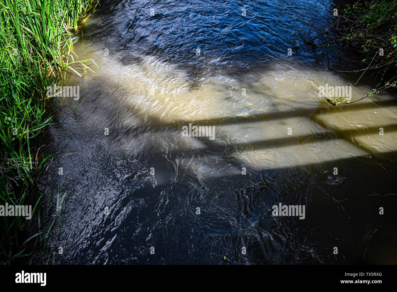 Un puente se refleja en el agua - el río Windrush en Cotswolds UK Foto de stock