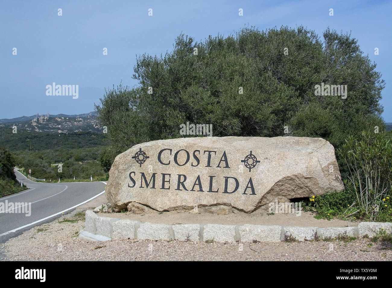 Rock con la carretera de la Costa Smeralda cartel de información de texto en Cerdeña, Italia. Foto de stock