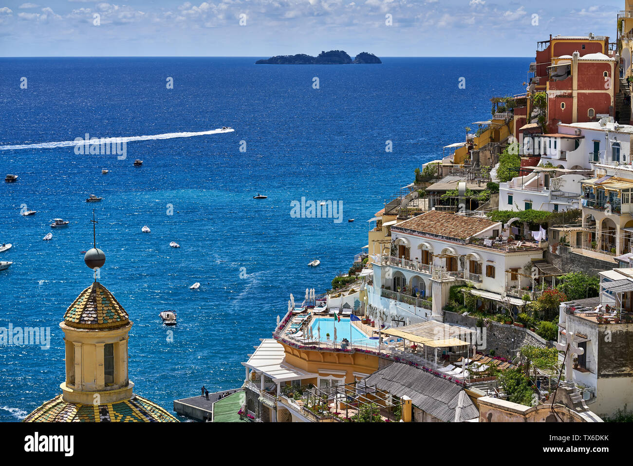 Magnífico soleado paisaje urbano de Positano hill-town en la costa de Amalfi en Italia. Hay muchas casas multicolores con la iglesia de Santa Maria Assunta en la Foto de stock