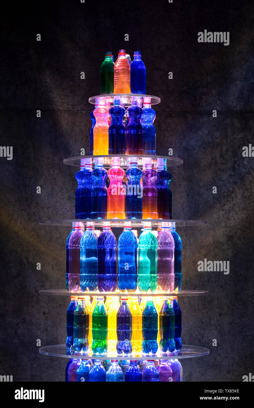 Botellas de plástico colorido apilados en estantes Foto de stock