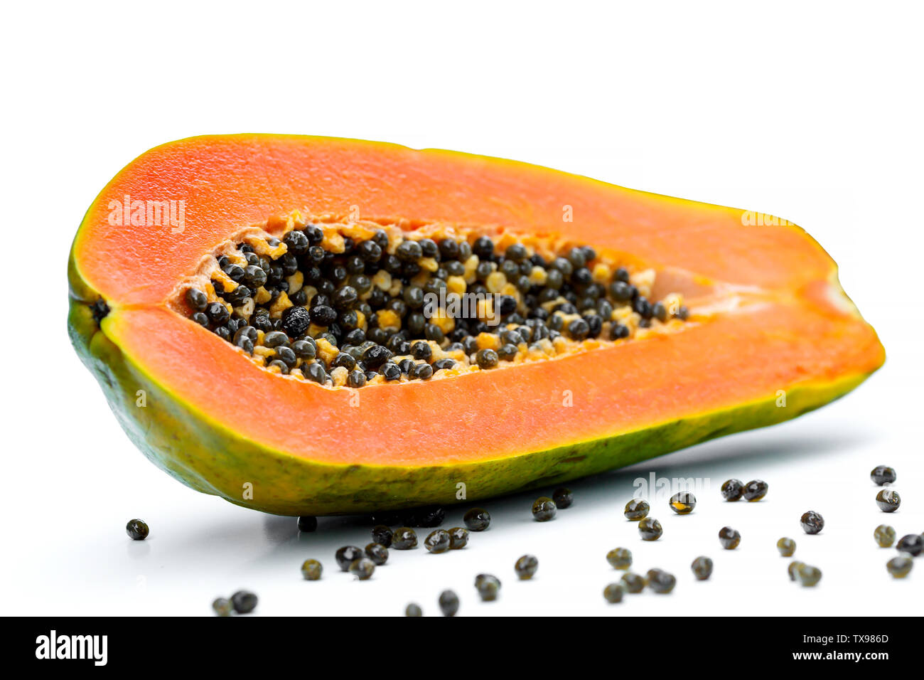 Media papaya dulce de frutas con semillas aislado sobre fondo blanco. Foto de stock