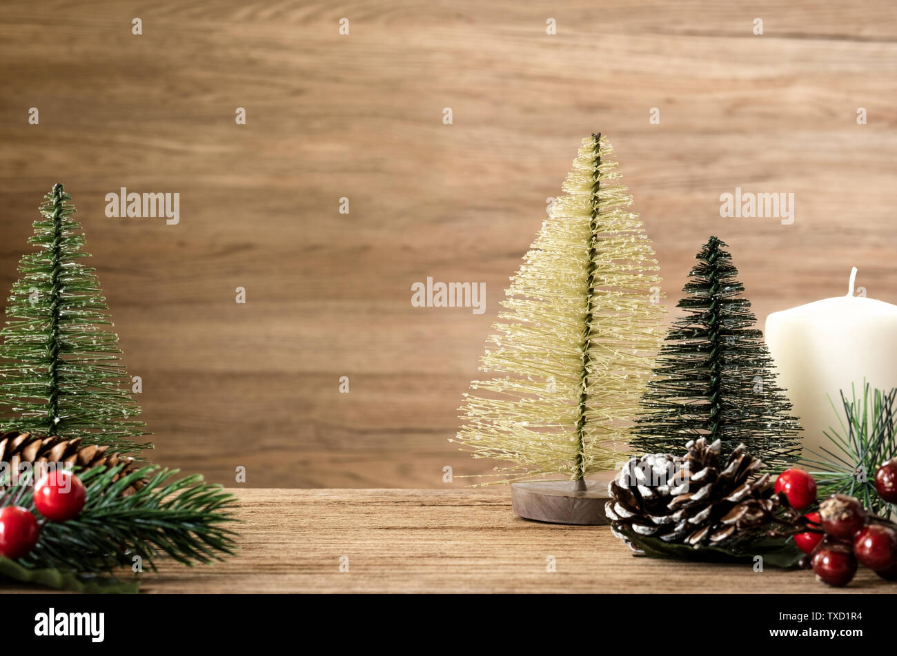 Árbol de Navidad decoración de mesa de madera con copia espacio.cono de pino,  muérdago y campana colgante bola con desenfoque de fondo de pared de  madera.Tarjeta de felicitación Fotografía de stock -