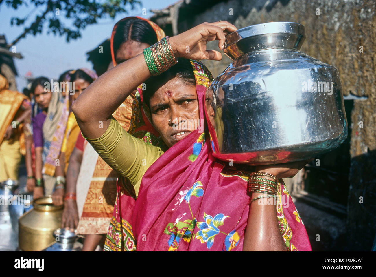 Mujeres de pie en la cola para recoger agua en tugurios, Bombay, Maharashtra, India, Asia Foto de stock