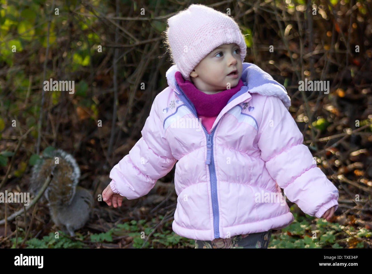 El bebé de 20 meses disfrutando del buen clima del exterior. Niño Niña retratos con luz natural. Little Girl cerrar Picture en la naturaleza, en invierno Foto de stock