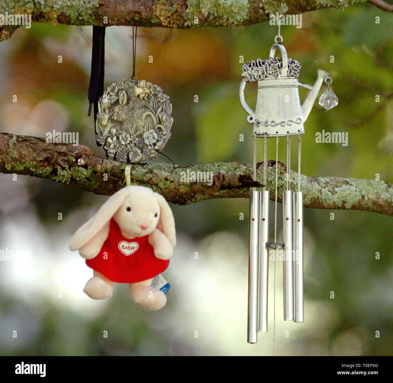 El Wind Chimes y pequeñas figuras Dogwood colgarse de una rama de árbol