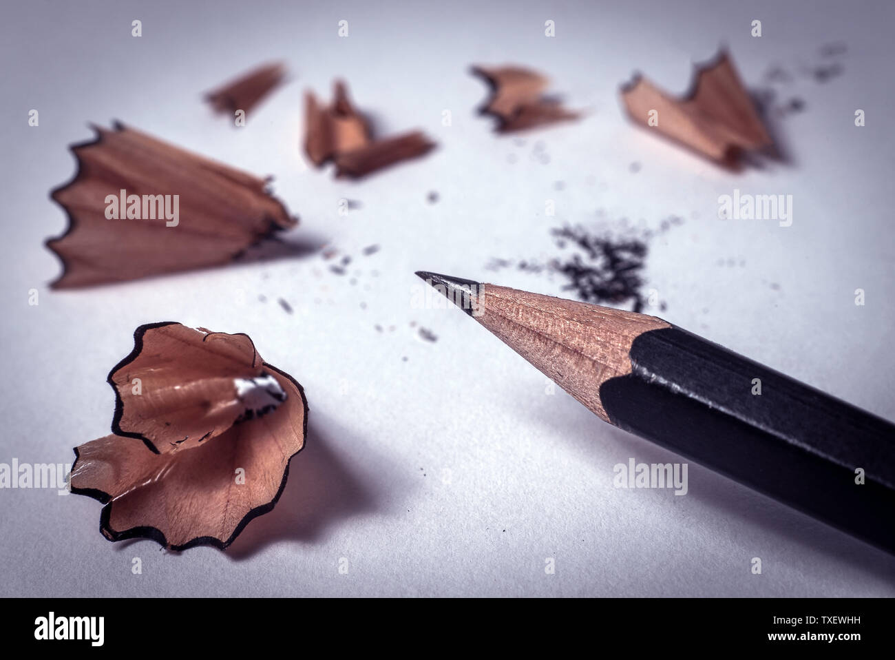 Primer plano de color negro con lápiz afilado remolino virutas de madera  después de afilar con un sacapuntas sobre papel blanco con copyspace -  Concepto de vuelta a la escuela Fotografía de