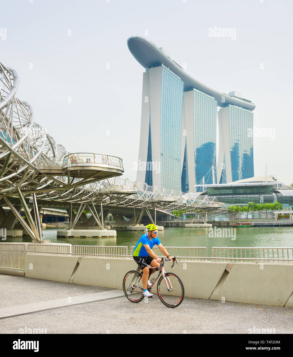 Singapur - Enero 14, 2017: el ciclista bicicleta Equitación, Singapur Marina Bay, Museo ArtScience y Helix Bridge en segundo plano. Foto de stock
