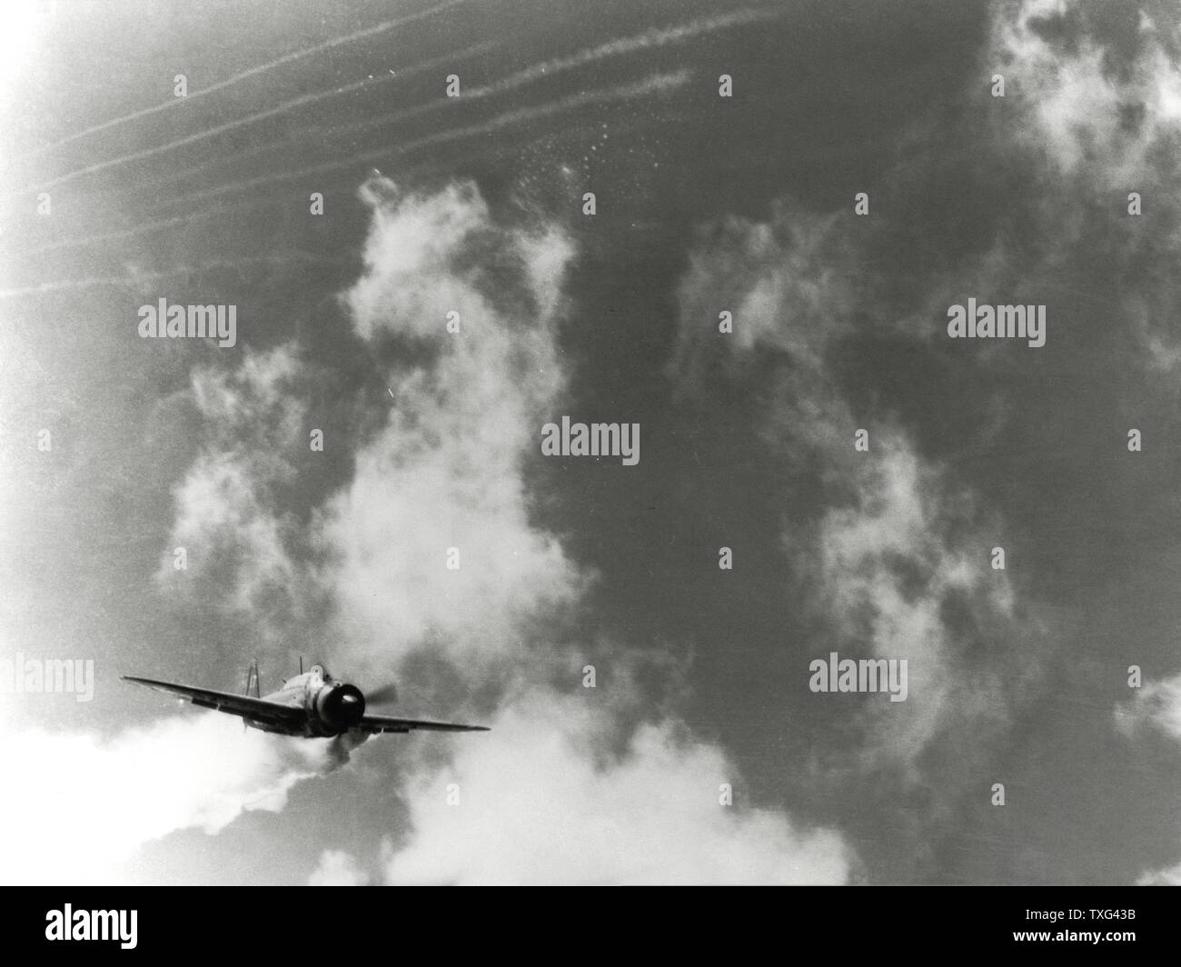 Kamikaze japonés (aviones Yokosuka D4Y3) piloteado por el teniente Yamaguchi, buceo en fuego en la cubierta de vuelo del portaaviones estadounidense USS Essex. La campaña del Pacífico, 25 de noviembre de 1944 Foto de stock