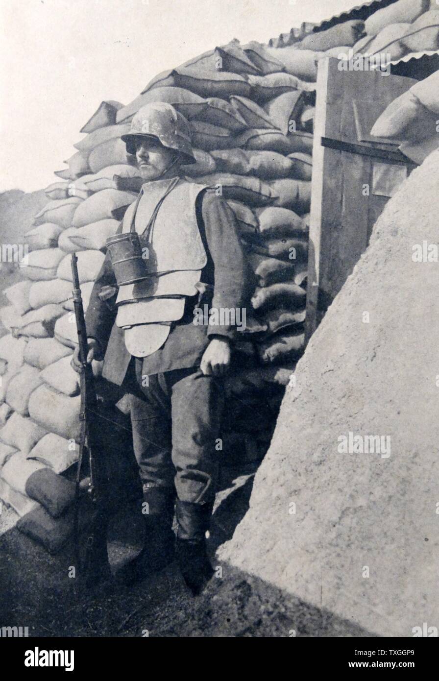 Soldado en las trincheras, vistiendo un traje fuertemente acorazados y portando un arma. Foto de stock