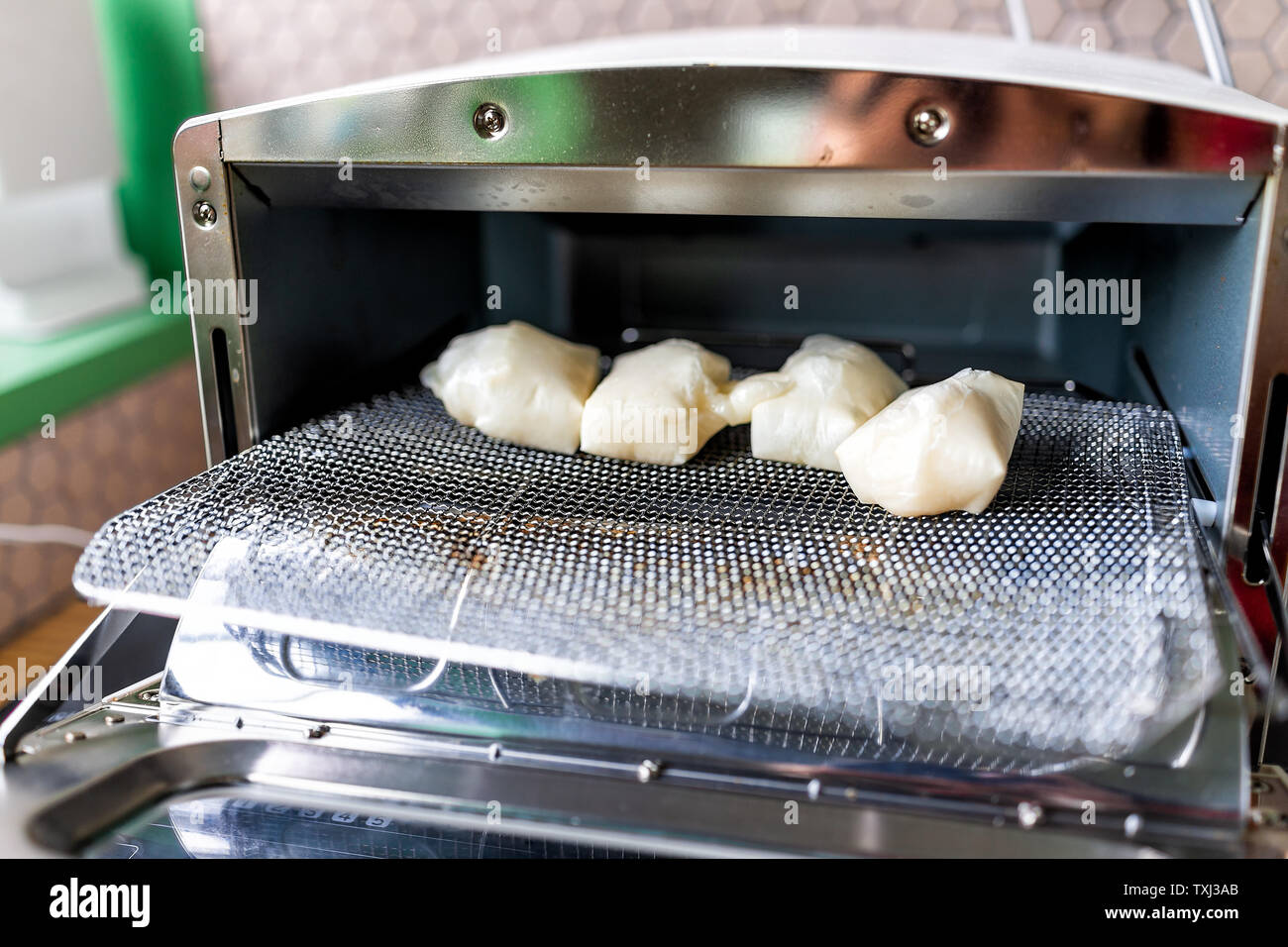 Pastel de arroz mochi pretencioso plazas después de ser horneado en pequeño horno  tostador en forma tradicional japonesa de cremallera Fotografía de stock -  Alamy
