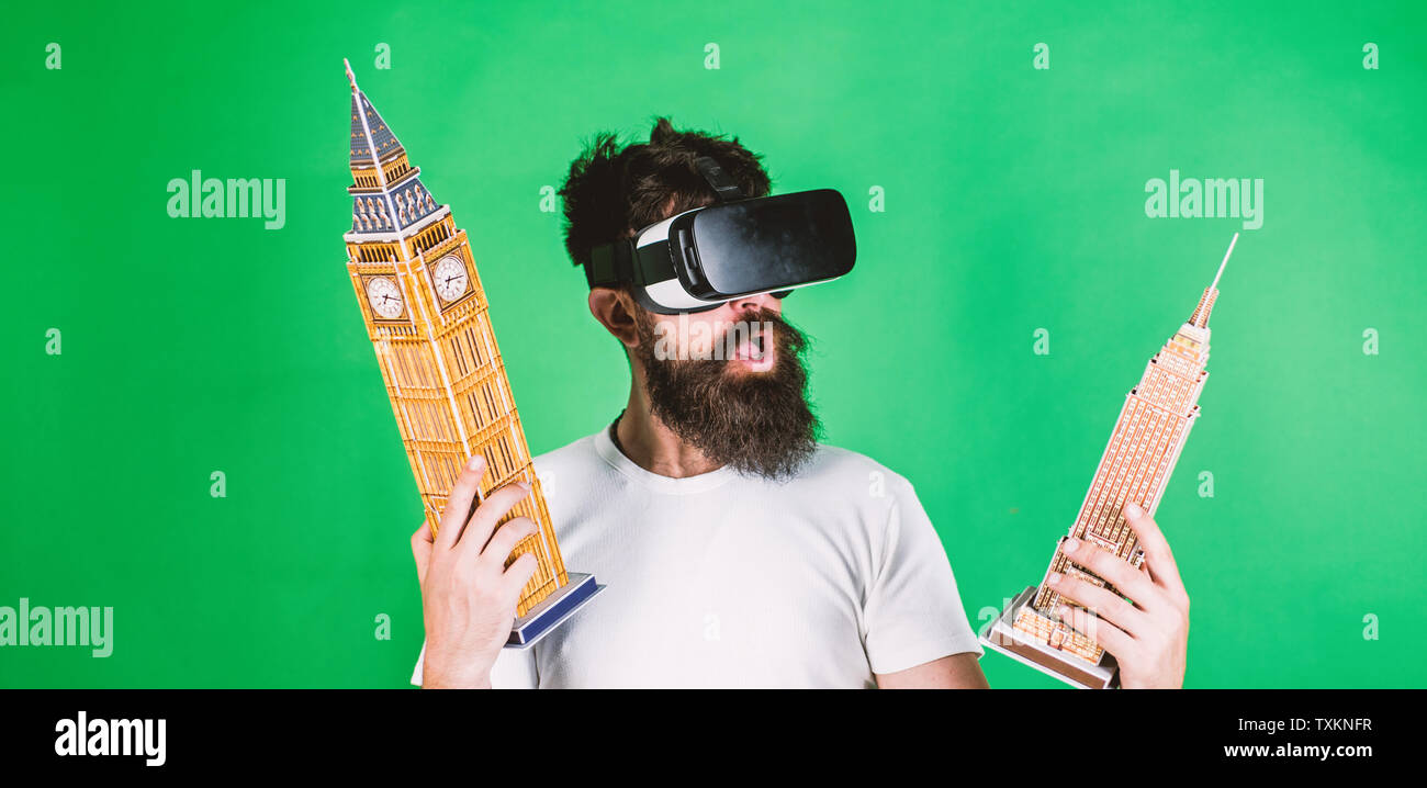 El hombre entusiasmado cara crea arquitectura, diseño de procesamiento 3D  de realidad virtual. Guy tiene el Big Ben y el Edificio Empire State.  Concepto de diseño 3D. Hombre con gafas, VR barba